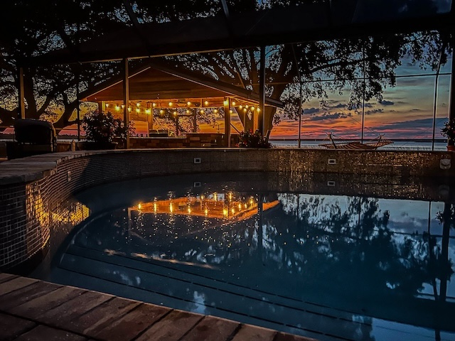 backyard pool at sunset with lights